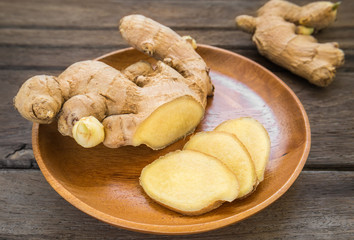 Ginger root sliced on wooden plate