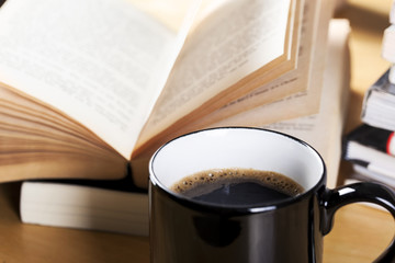 coffee in black cup and book pile