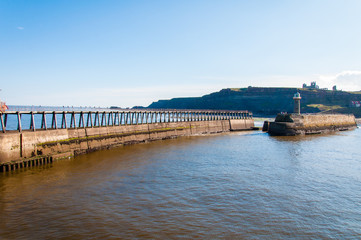 Fototapeta na wymiar Scenic view of Whitby Pier in sunny day in North Yorkshire, UK.