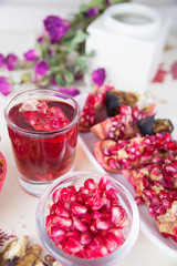 a piece of a pomegranate, a glass of pomegranate juice