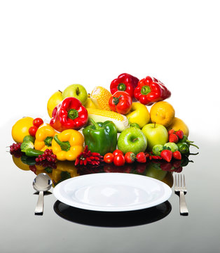 Fresh vegetables and fruits with empty plate