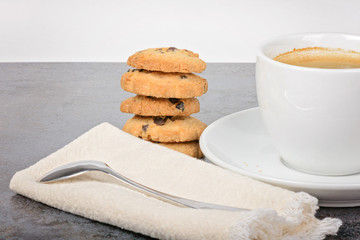 Cup of coffee with cookies and spoon on table