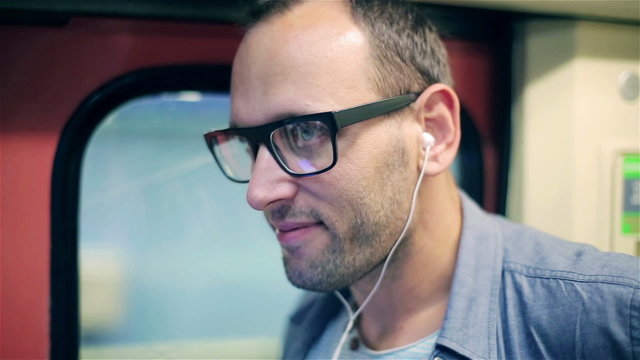 Happy man listening music and traveling by subway, steadycam 
