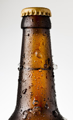 Bottle of ice cold beer with ice and drops