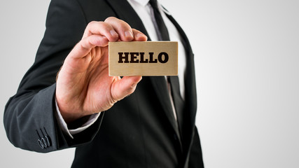 Businessman holding a wooden sign saying Hello