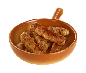 sausages wrapped in bacon in a frying pan