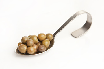 green olive on the spoon isolated white background