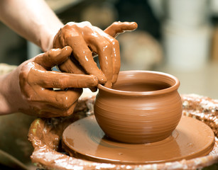 hands of a potter, creating an earthen jar