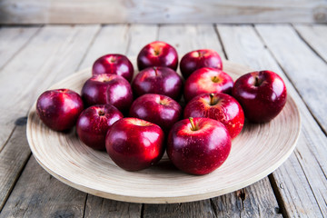 Fresh harvest of apples. red grapes on wooden background.