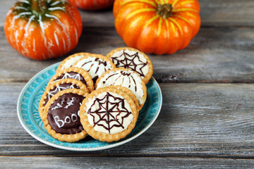 Naklejka na ściany i meble Tasty Halloween cookies on plate, on wooden table