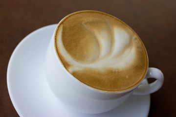 Cup of art latte on a cappuccino coffee