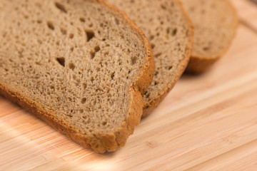 Three slices of rye bread on a wooden table
