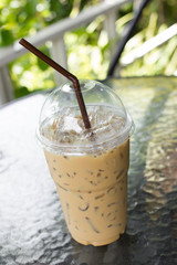 Iced coffee with straw in plastic cup