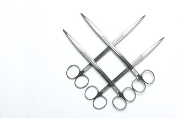Four crossed surgical scissors on a white background