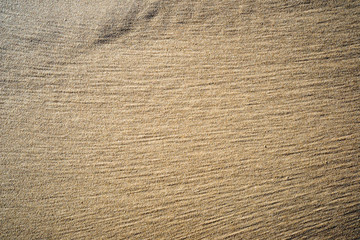 A background texture of unrefined, damp and grainy natural golde