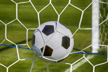 Fototapeta premium Soccer football in Goal net field. 