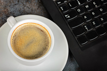 Closeup shot of cup of coffee and kayboard