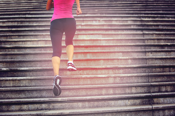 sports woman legs running up on stone stairs 