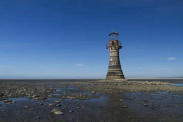 Fototapeta na wymiar Ruined derelict lighthouse, space to top left. Whiteford Sands,