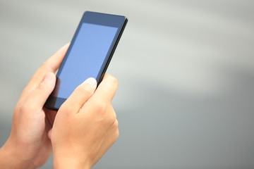 young woman hands use cellphone in city 