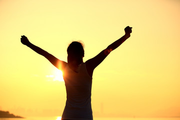 Fototapeta premium woman open arms under the sunrise seaside