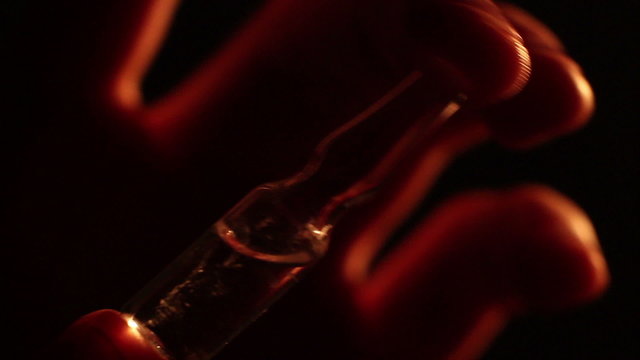 Person holding medical ampoule with dangerous substance, drugs