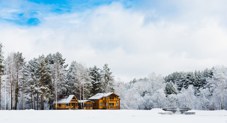 Wooden houses in a nature area covered with snow.
