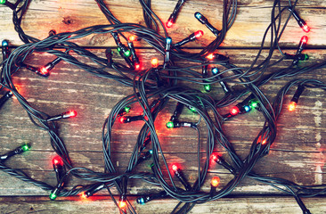 Colorful Christmas lights on wooden  rustic background. filtered