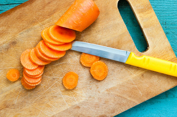 fresh carrot and knife on wooden board