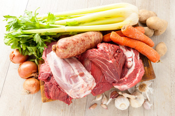 Tagli di carne bovina e suina cruda appoggiati sul tagliere