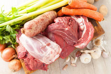 Tagli di carne bovina e suina cruda appoggiati sul tagliere