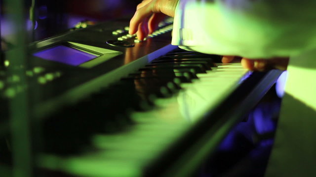 Musician playing on keyboards close up