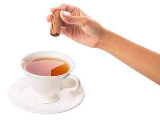Female hand with a cup of tea and cinnamon stick