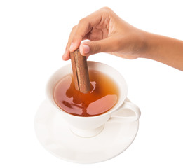 Female hand with a cup of tea and cinnamon stick