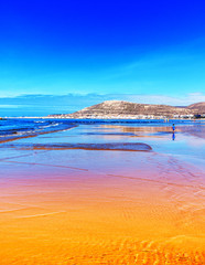 Orange und blauer Strand bei Ebbe