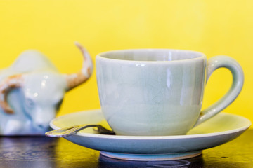 Cup of coffee on yellow background.