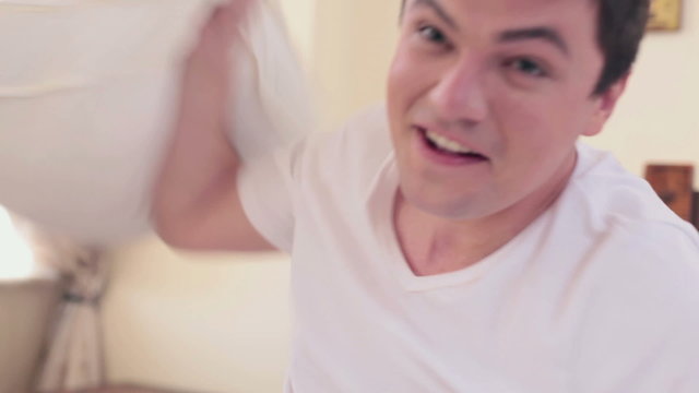 POV of girl having pillow fight with handsome boyfriend