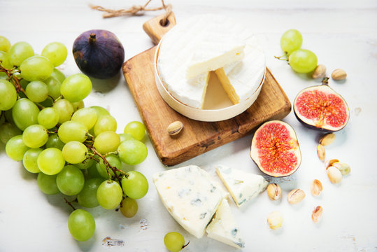 various types of cheese with figs and grapes