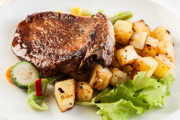 Fried pork with potatoes and vegetables salad