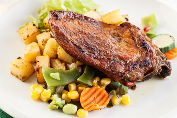 Fried pork with potatoes and vegetables salad