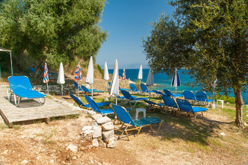 Sunbeds and umbrellas on the beach in Corfu Island, Greece