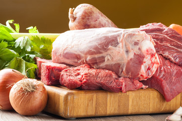 Tagli di carne bovina e suina cruda appoggiati sul tagliere