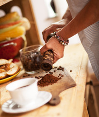 Senior woman making ground coffee in her kitchen