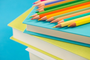 Colorful pencils on stack of books