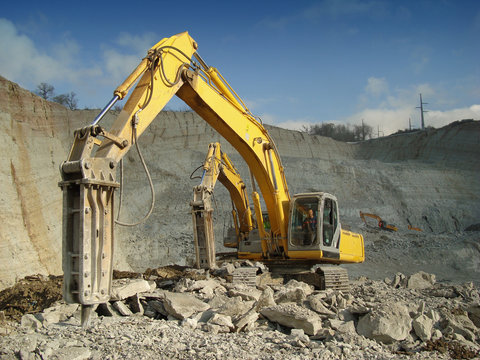 Photo of machines with a hydraulic hammer extracting rubble at the quarry