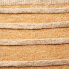Fototapeta na wymiar Knitted beige sweater fragment