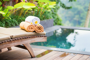 Towels with white frangipani flowers in spa
