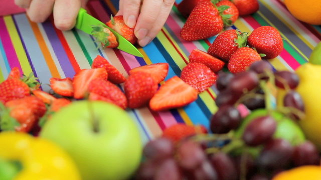 slicing strawberries in colorful kitchen scene