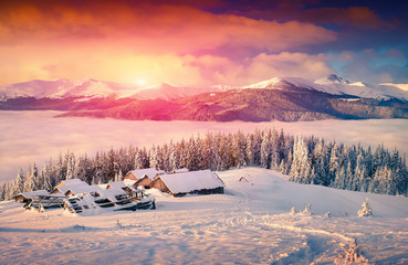 Colorful winter sunrise in the foggy mountains