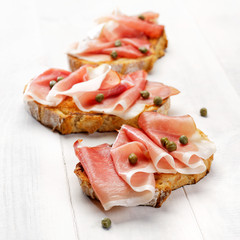 Grilled country bread with ham and capers